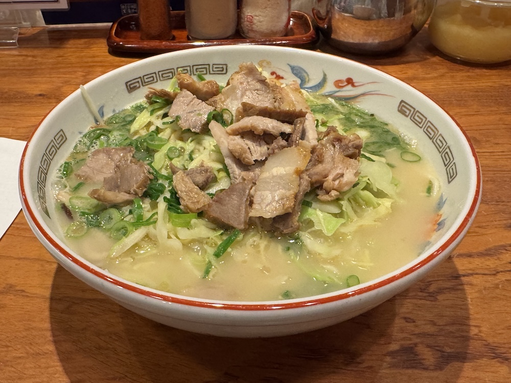 こむらさきのラーメン。豚骨スープに茹でたキャベツと刻んだチャーシューが乗っている